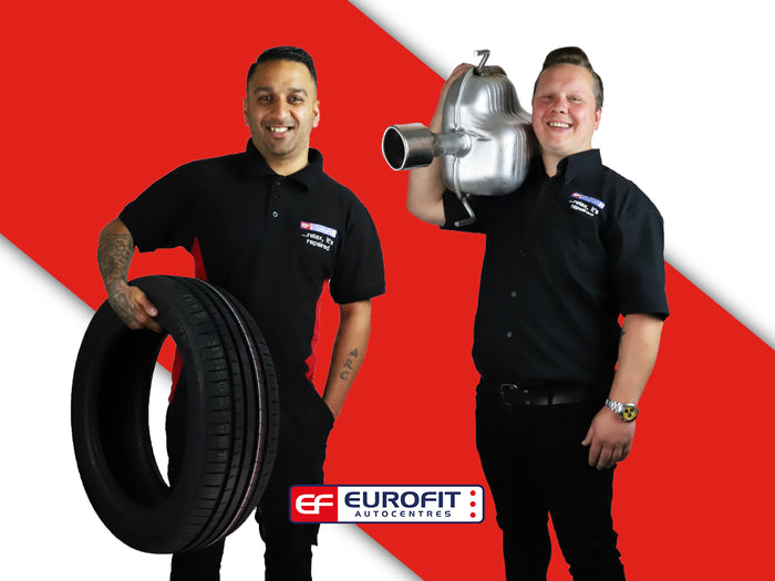 Two Eurofit technicians carrying car tyre and engine, with red background